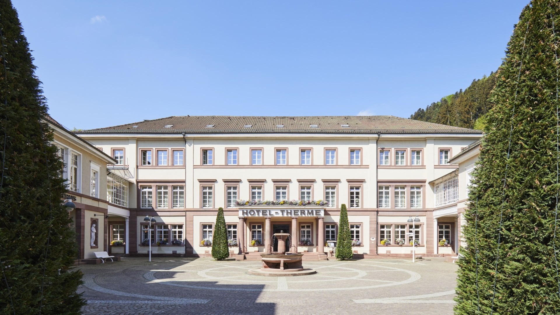 Außenansicht des Hotel Therme Bad Teinach mit Innenhof und Brunnen