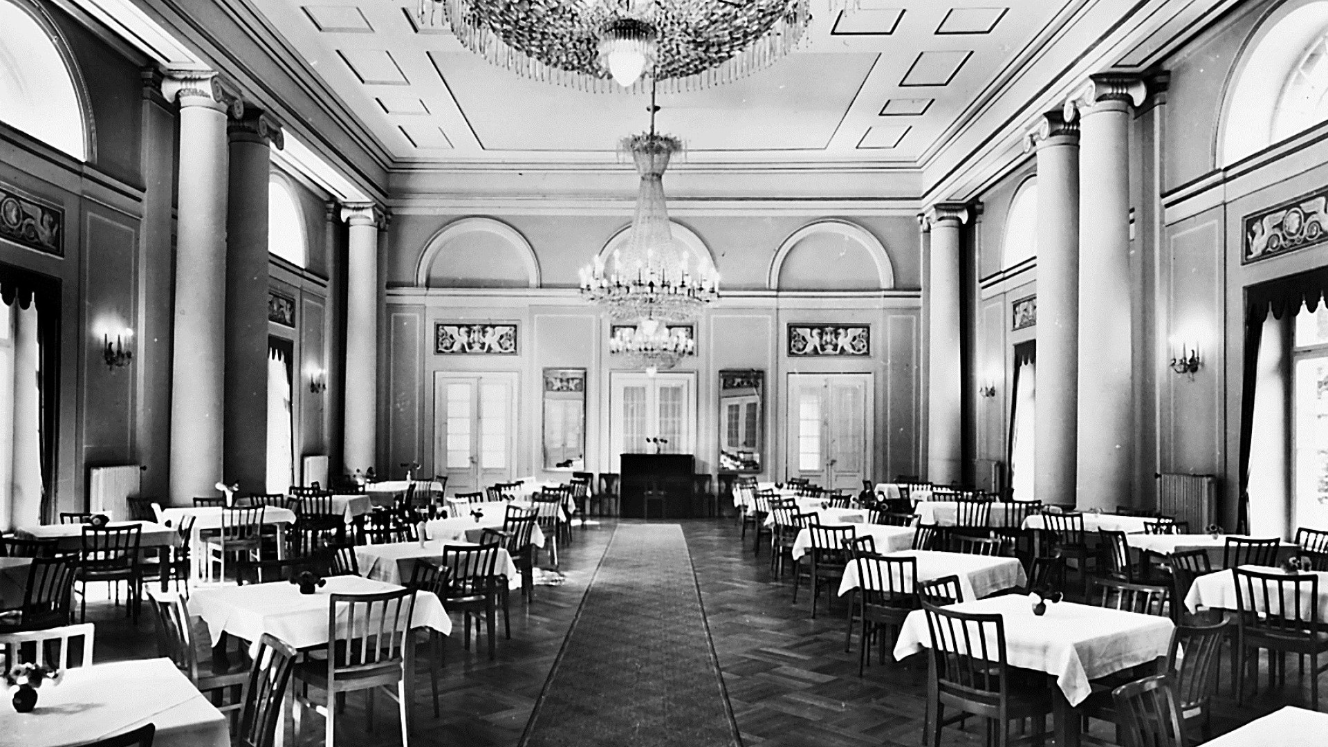 Festsaal des Hotel Therme Bad Teinach mit Kristalllüstern, hohen Säulen und gedeckten Tischen