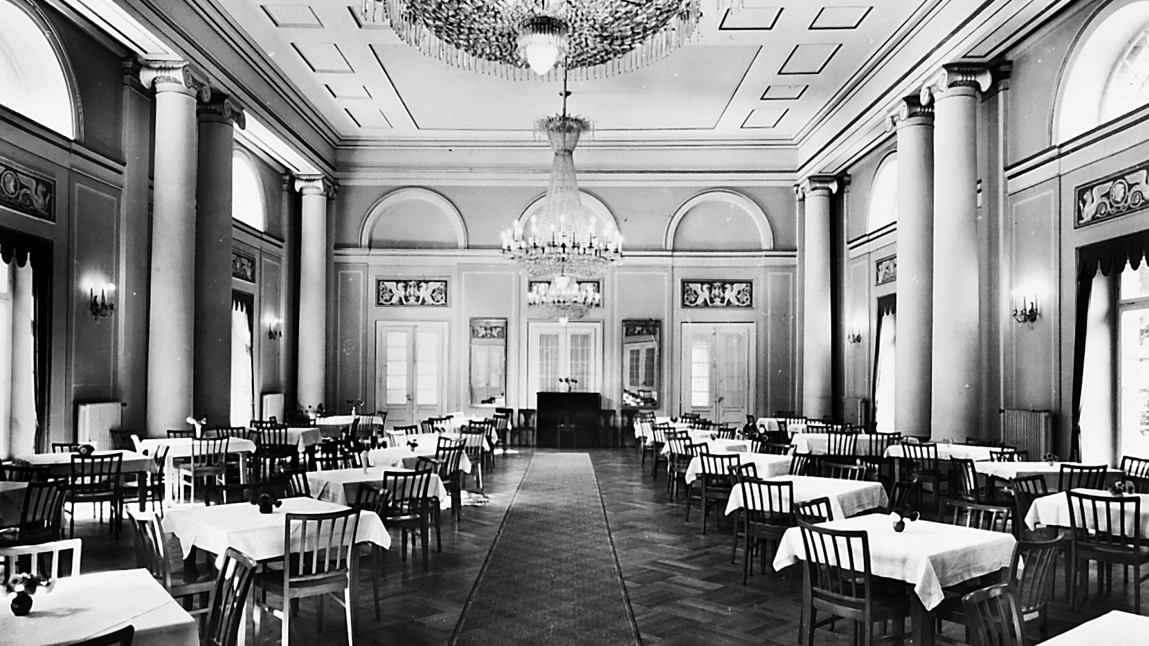 Festsaal des Hotel Therme Bad Teinach mit Kristalllüstern, hohen Säulen und gedeckten Tischen