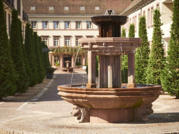 Blick durch Wasserspritzer des Brunnens auf die Hotelanlage