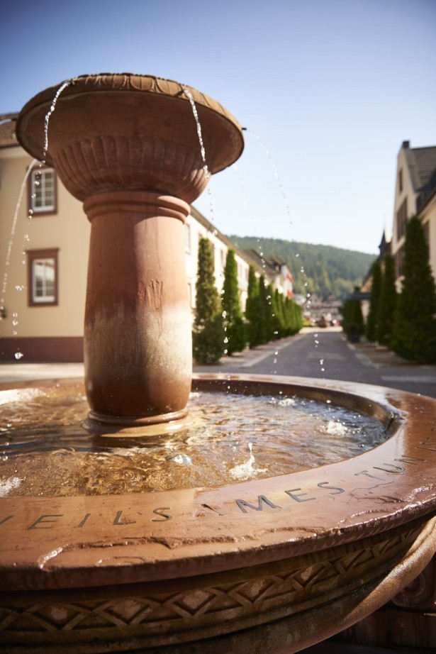 Nahaufnahme des Brunnens mit Wasserspiel im Sonnenlicht
