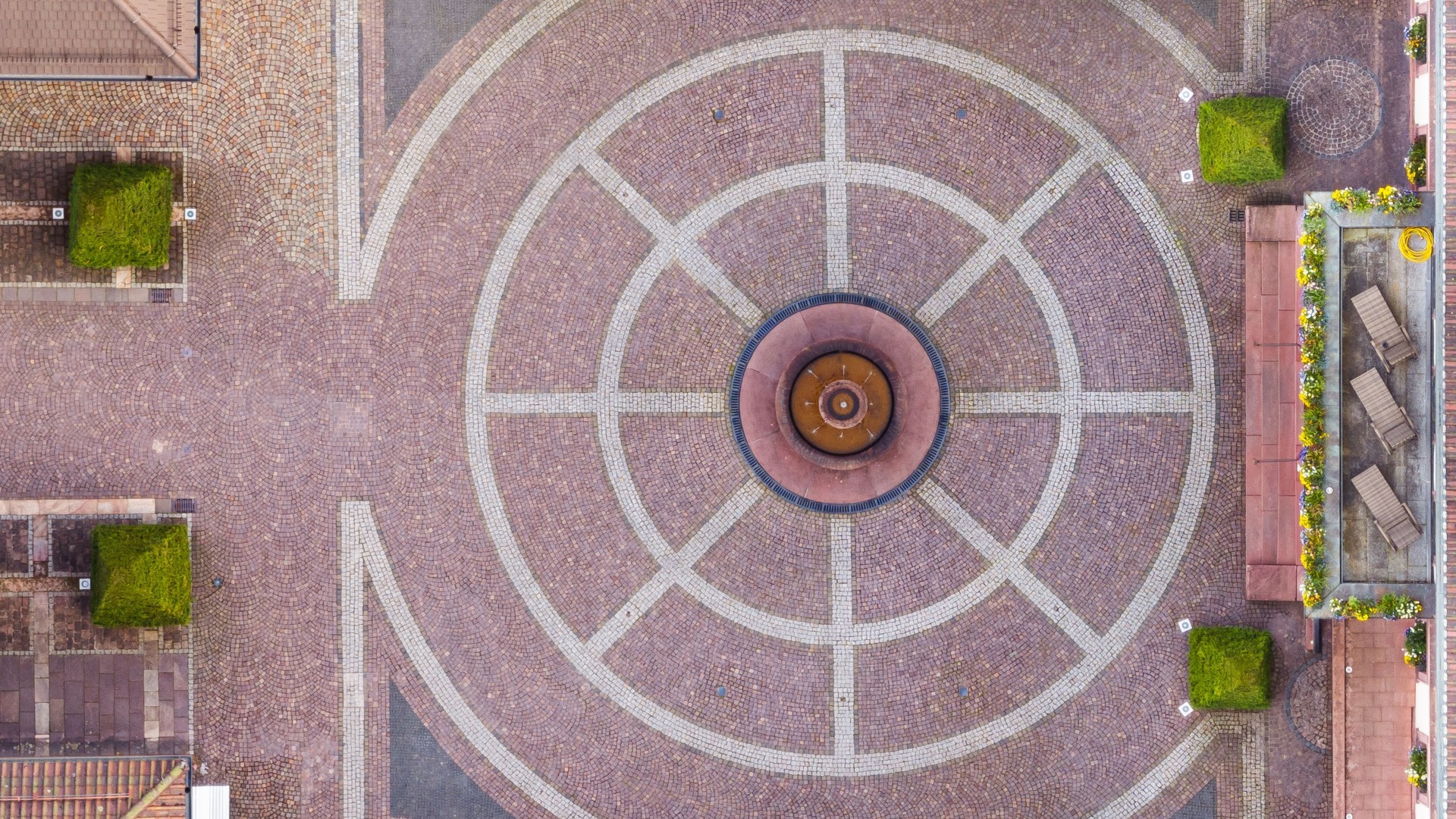 Luftaufnahme des gepflasterten Hotelhofs mit geometrischem Brunnenmuster