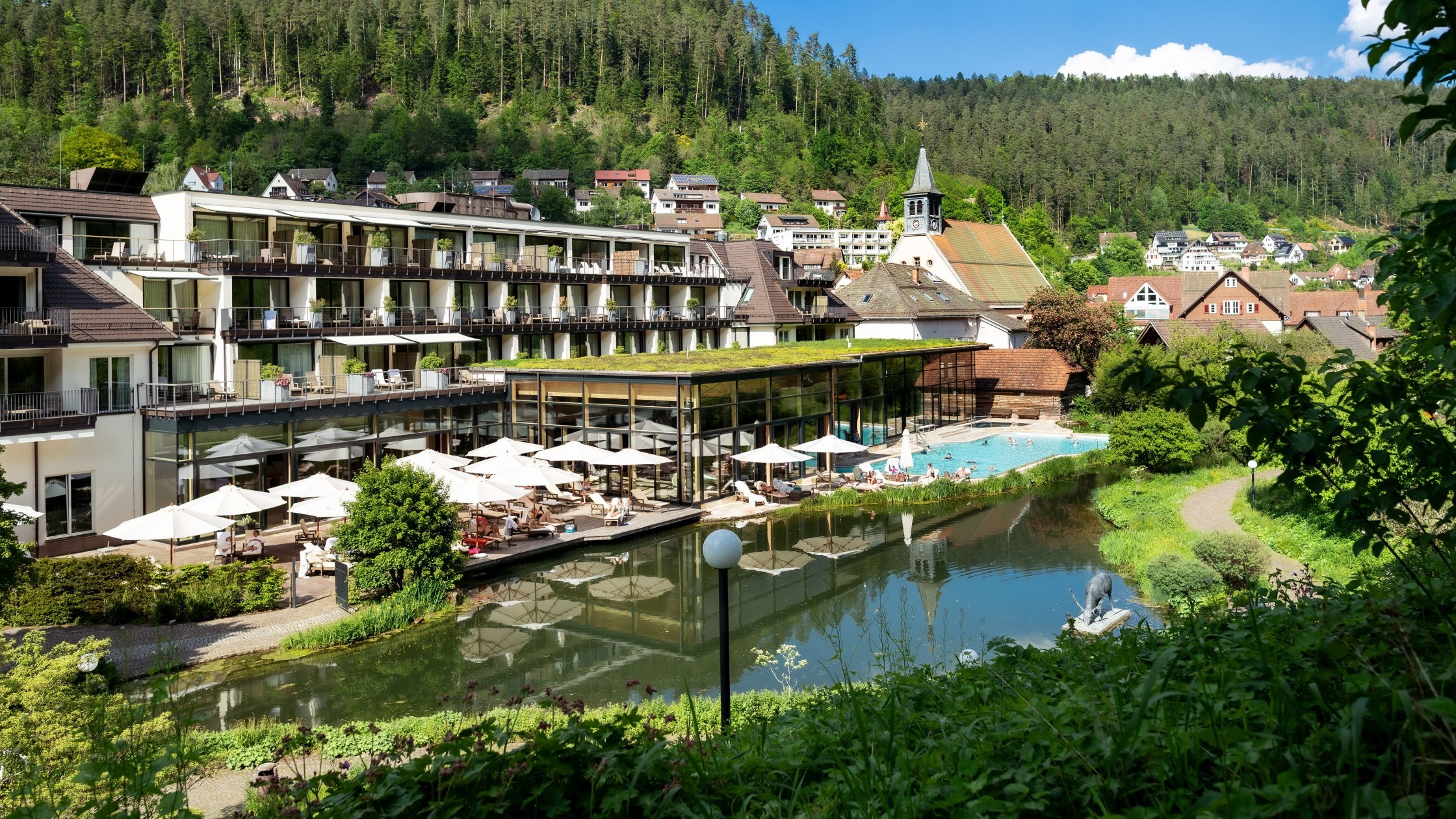 Außenansicht des Wellnesshotels Therme Bad Teinach mit Seeterrasse und grüner Umgebung