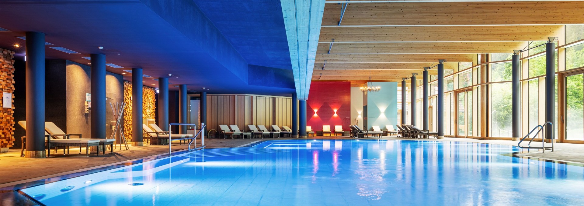 Mineraltherme mit großem Innenpool, Liegestühlen und modernem Lichtkonzept