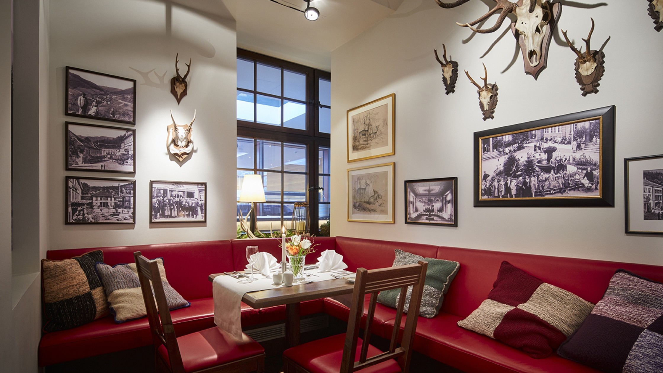 Urige Sitzecke mit roten Polstern und Jagdtrophäen im Restaurant in Bad Teinach