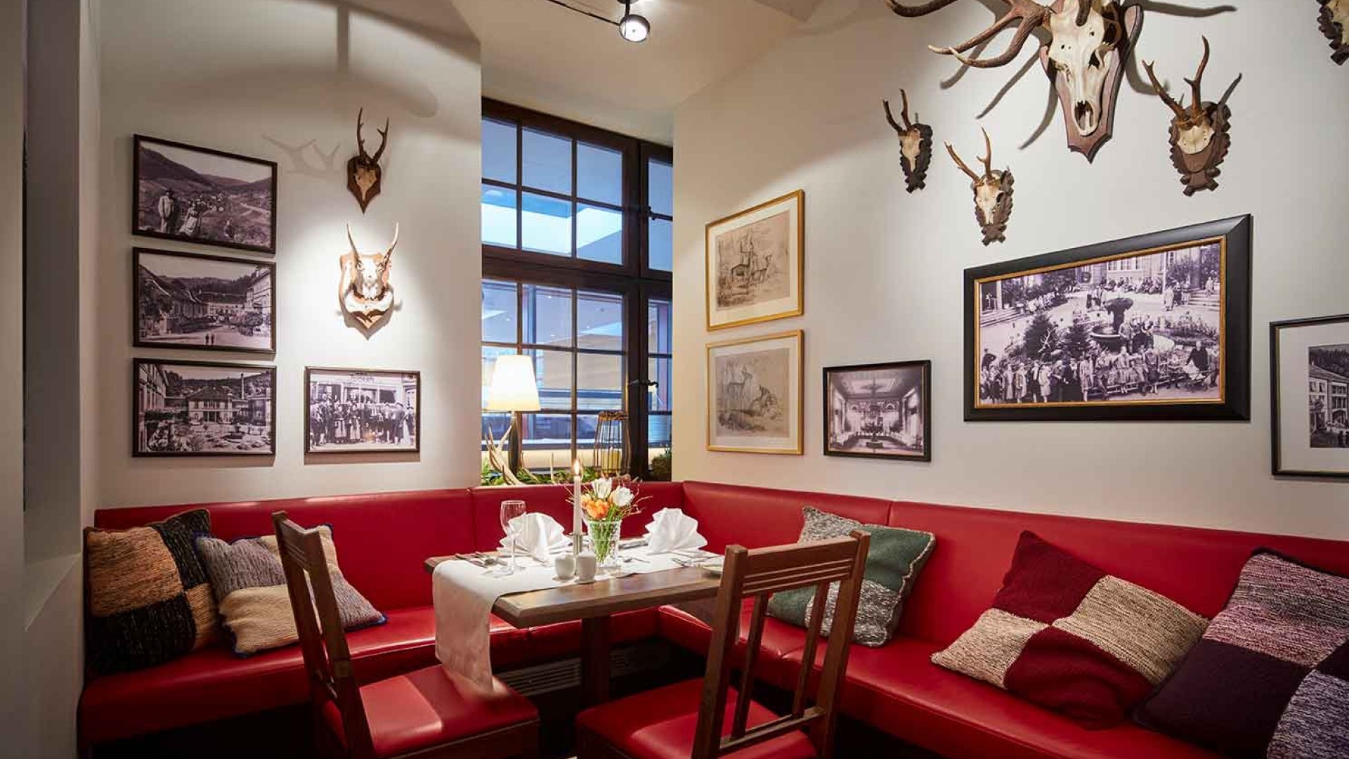 Gemütliche Sitzecke mit rotem Sofa und nostalgischer Wanddekoration