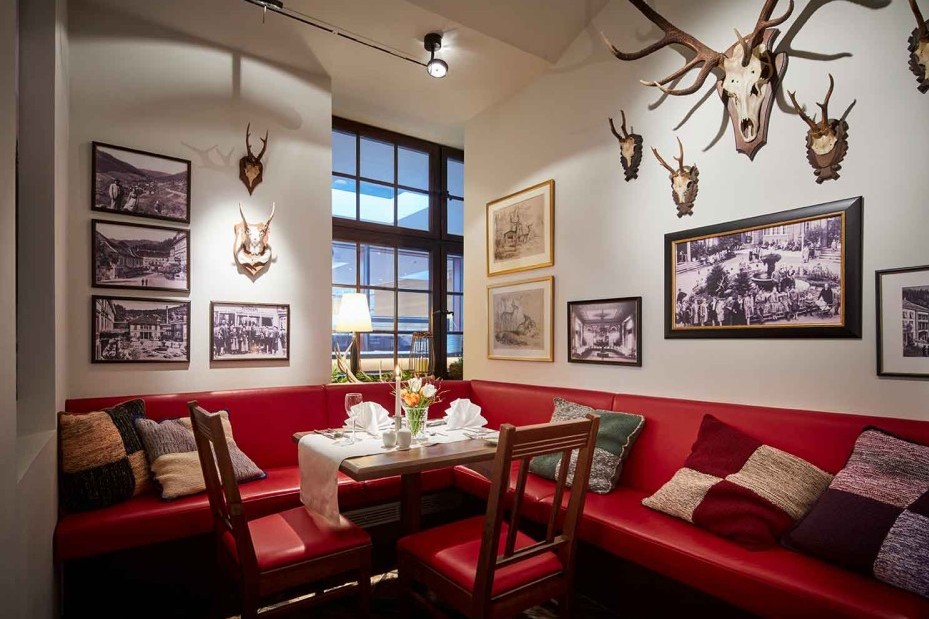 Gemütliche Sitzecke mit rotem Sofa und nostalgischer Wanddekoration