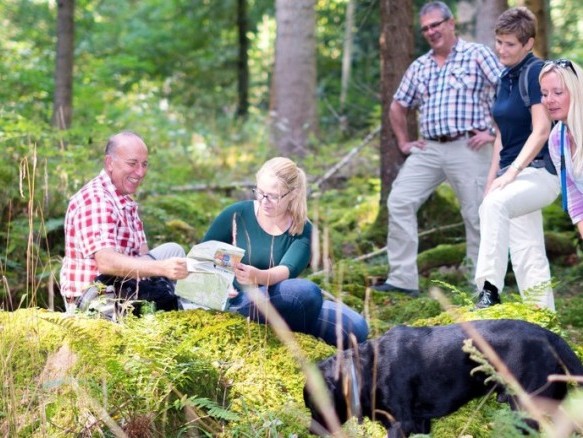 Wandergruppe mit Hund bei einer Rast im Teinachtaler Wald