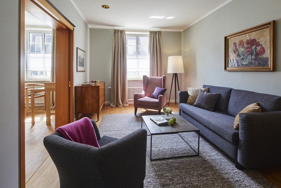 Elegantes Wohnzimmer mit Sofa, Sessel und stilvoller Einrichtung