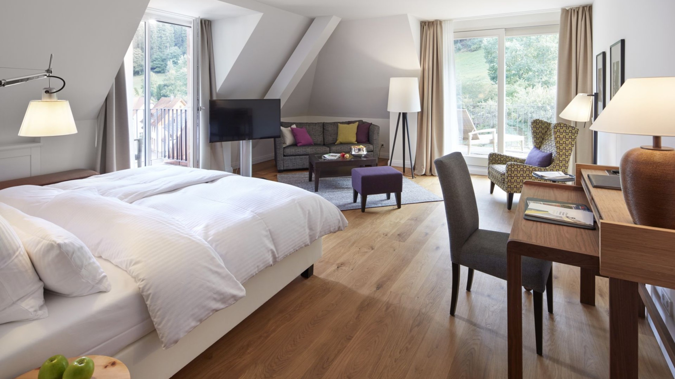 Geräumiges Hotelzimmer mit Sitzecke und Balkonblick