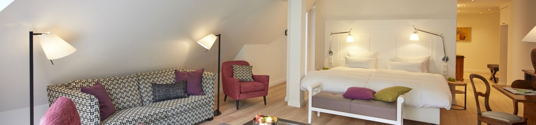 Großzügige Suite im Hotel Therme Bad Teinach mit gemütlicher Sitzecke, Doppelbett und modernem Interieur