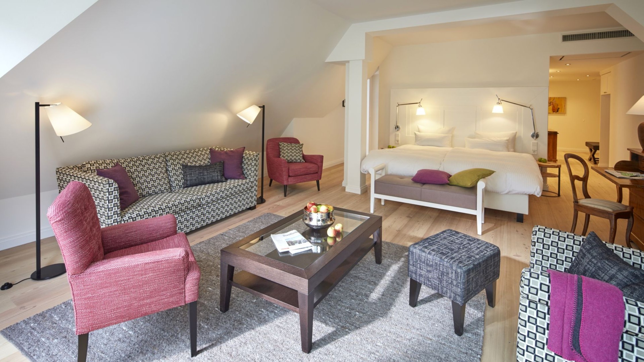 Großzügige Suite im Hotel Therme Bad Teinach mit gemütlicher Sitzecke, Doppelbett und modernem Interieur