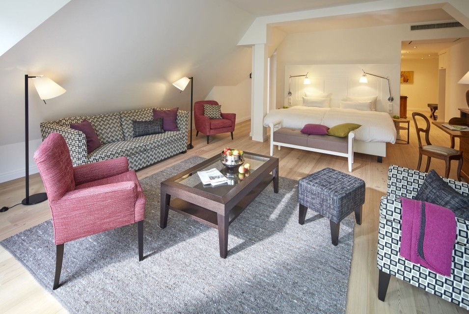 Großzügige Suite im Hotel Therme Bad Teinach mit gemütlicher Sitzecke, Doppelbett und modernem Interieur