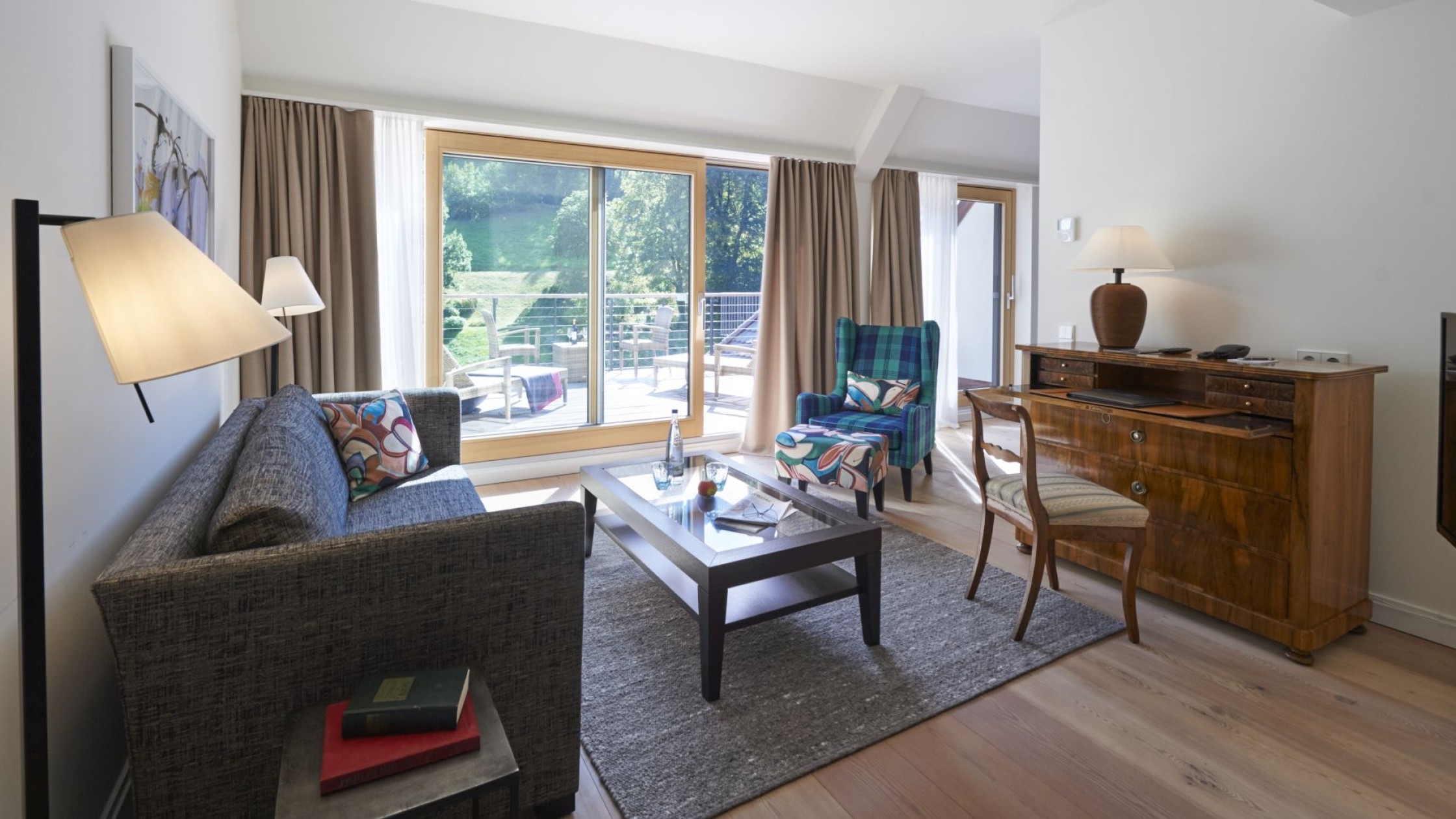 Helle Hotelsuite mit Wohnzimmerbereich und großer Terrasse