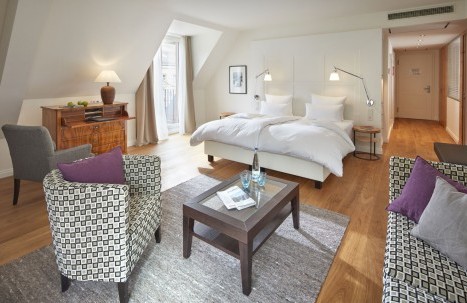 Helles Doppelzimmer mit modernem Design, Sitzbereich und Schreibtisch