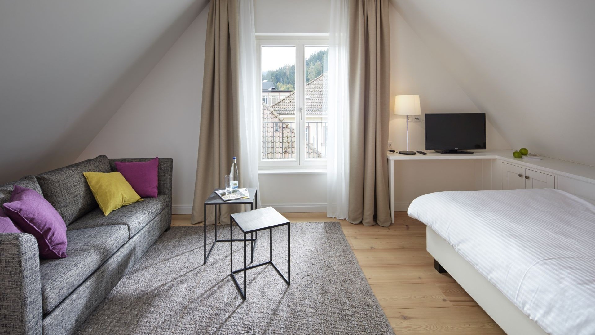 Komfortables Doppelzimmer im Hotel Therme Bad Teinach mit Sofa, Schreibtisch und Blick auf den Schwarzwald