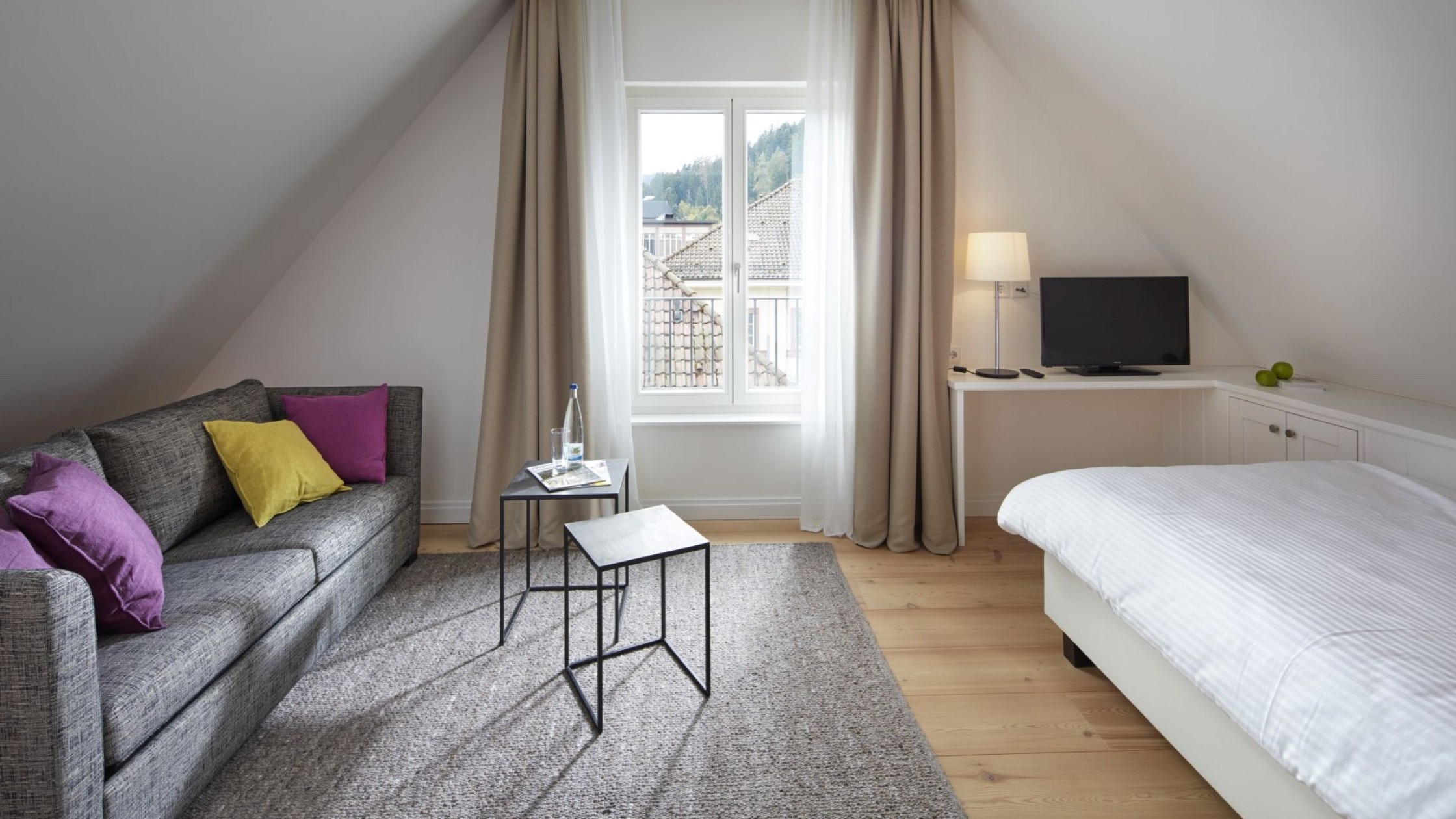 Komfortables Doppelzimmer im Hotel Therme Bad Teinach mit Sofa, Schreibtisch und Blick auf den Schwarzwald