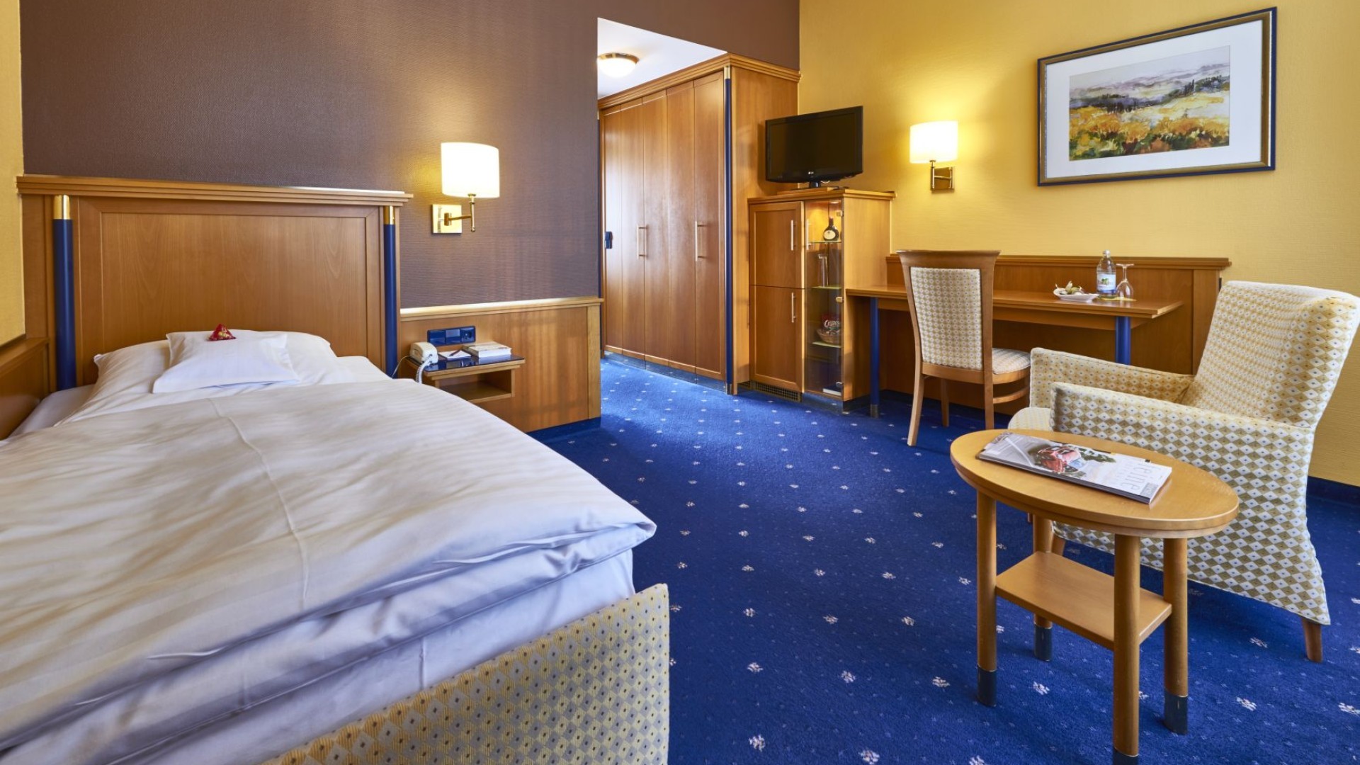 Komfortables Einzelzimmer mit Schreibtisch und Sitzbereich