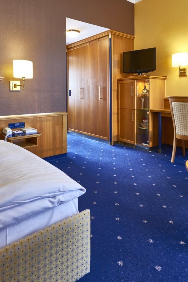 Komfortables Einzelzimmer mit Schreibtisch und Sitzbereich