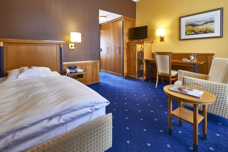 Komfortables Einzelzimmer mit Schreibtisch und Sitzbereich