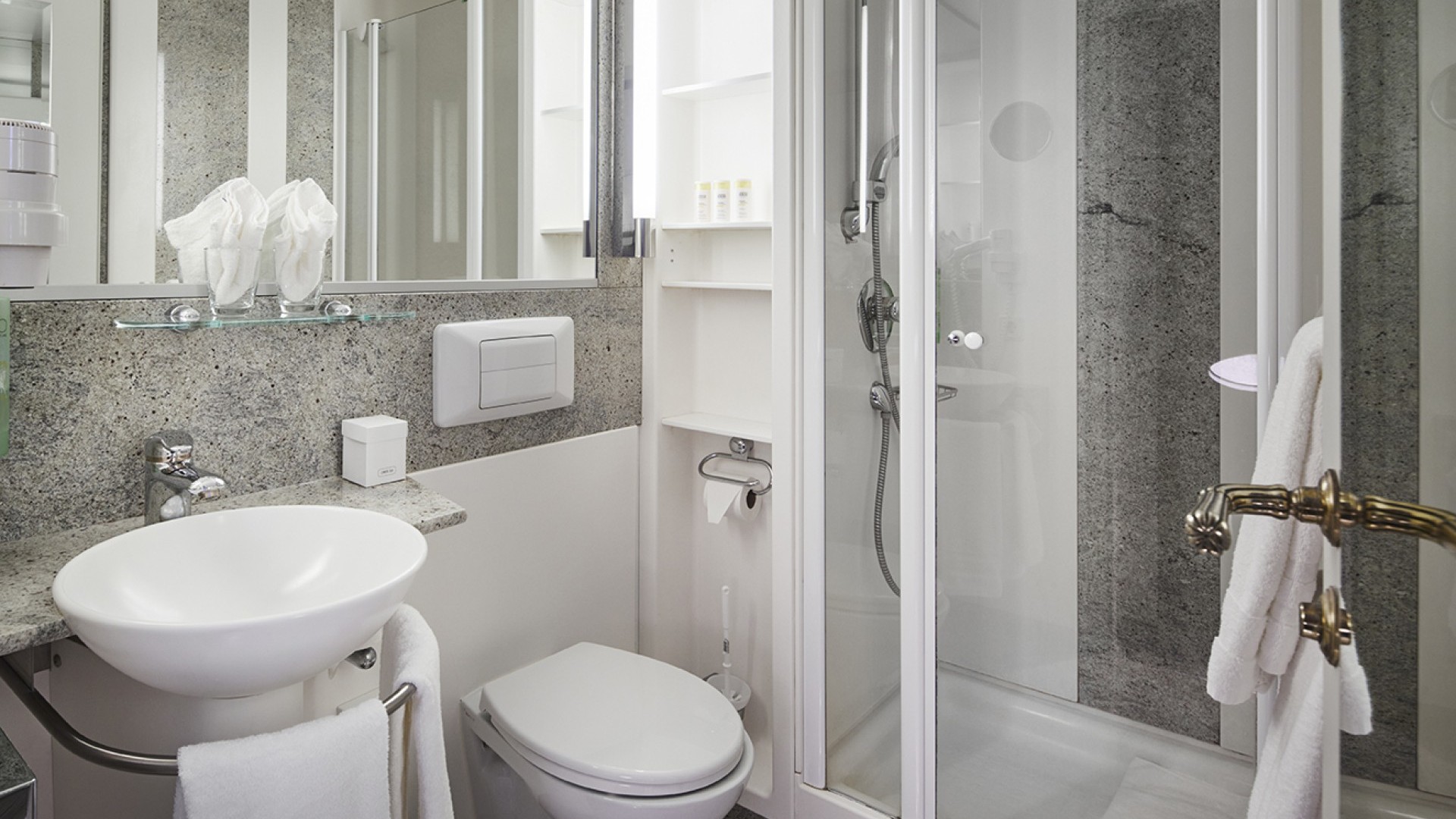 Kompaktes Bad mit Glasdusche, Waschbecken und grauem Naturstein-Design