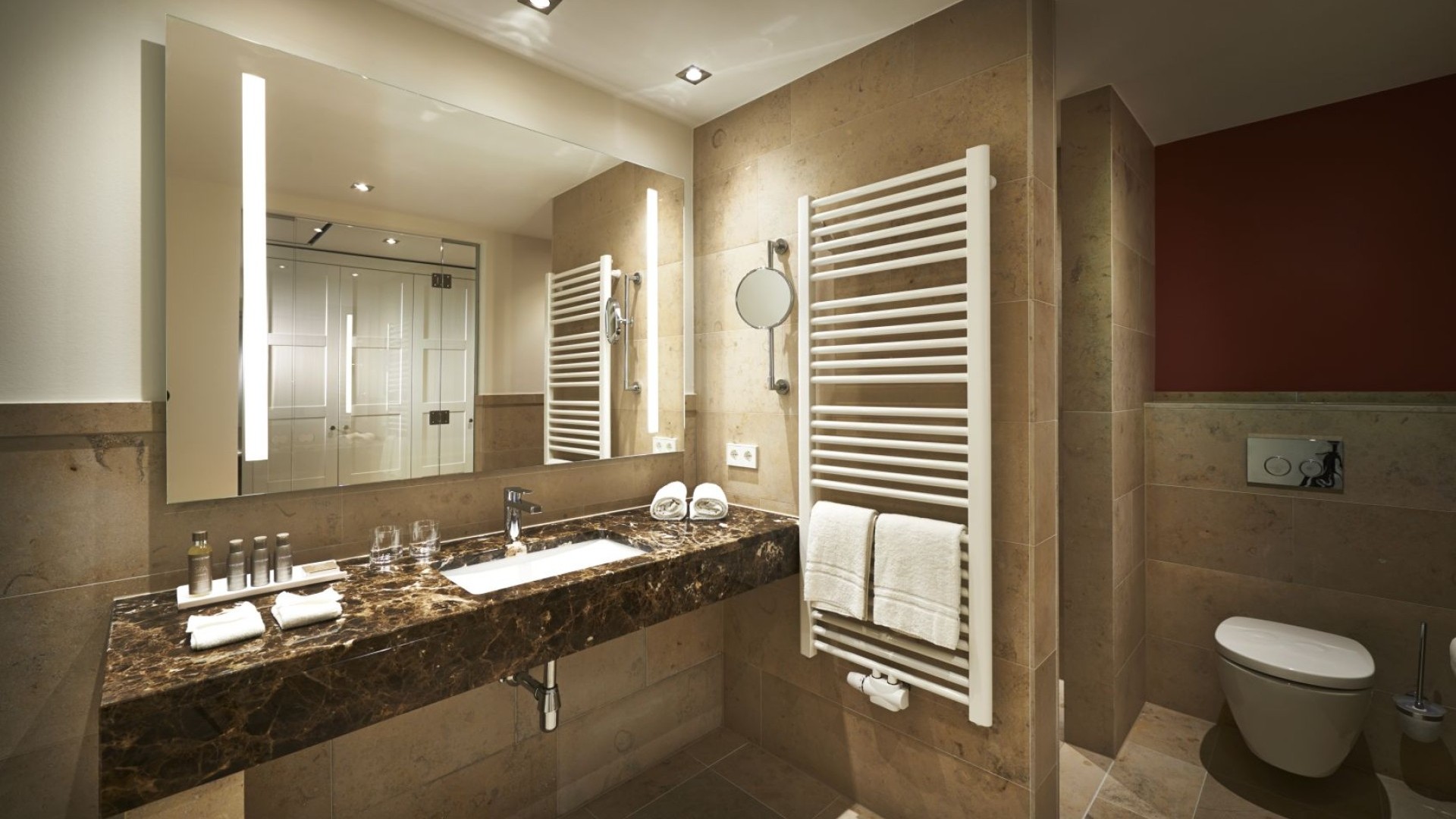 Modernes Badezimmer mit Marmorwaschtisch und Handtuchheizkörper