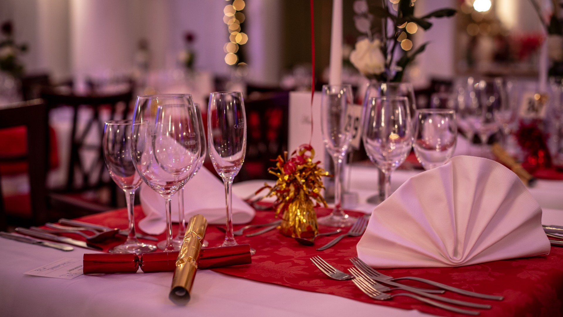 Festlich gedeckter Tisch mit Gläsern und roter Dekoration